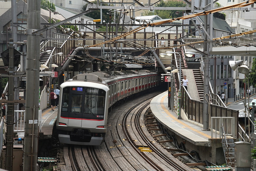 Japanese commuter train arriving at elevated station platform