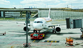 White Airplane Being Pushed Back at Airport Gate