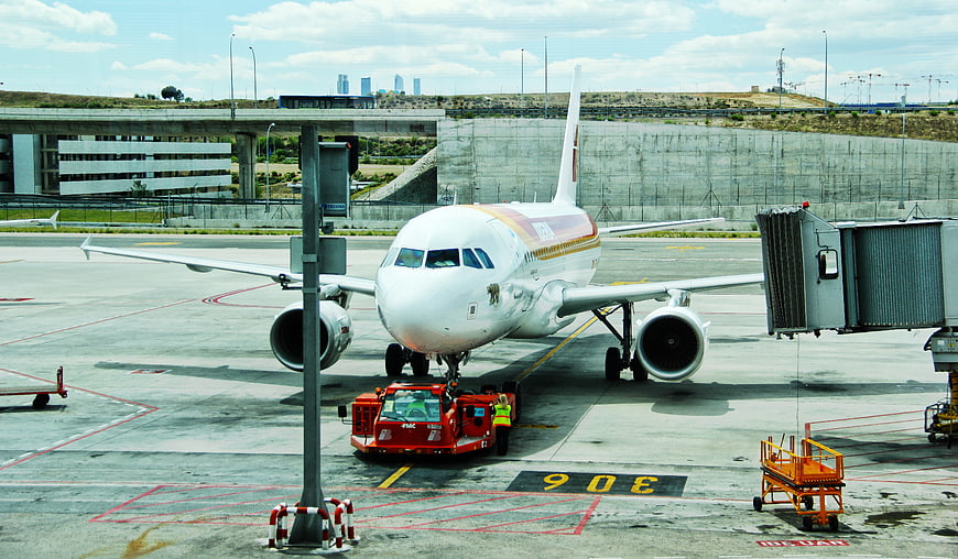 White Airplane Being Pushed Back at Airport Gate