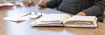 Open Notebook and Glasses on Wooden Office Desk