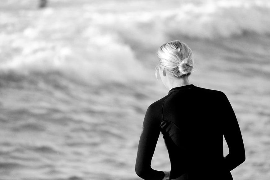 Woman in Wetsuit Looking at Ocean Waves