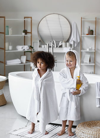 Two Cute Children in White Bathrobes in Modern Bathroom