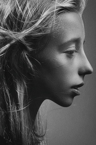 Black and white profile portrait of a woman with windblown hair