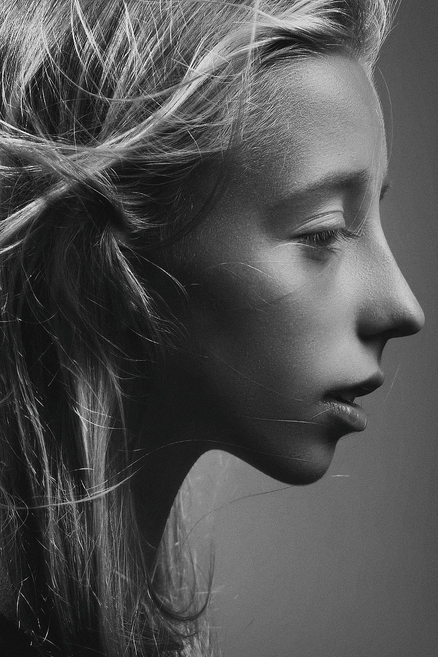 Black and white profile portrait of a woman with windblown hair