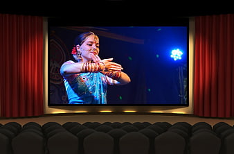 Indian classical dancer performing on cinema screen in theater