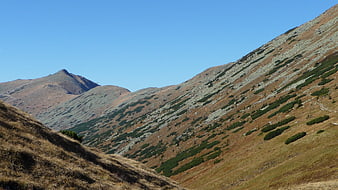 Autumn mountain landscape with rocky slopes and blue sky