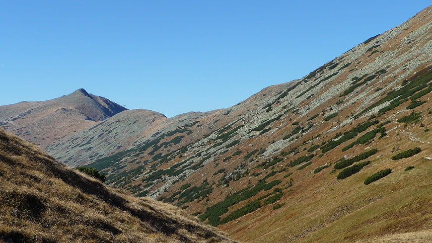 Autumn mountain landscape with rocky slopes and blue sky