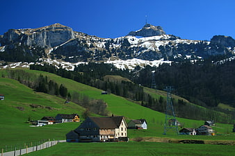 Swiss Alps landscape with green meadows and traditional chalets