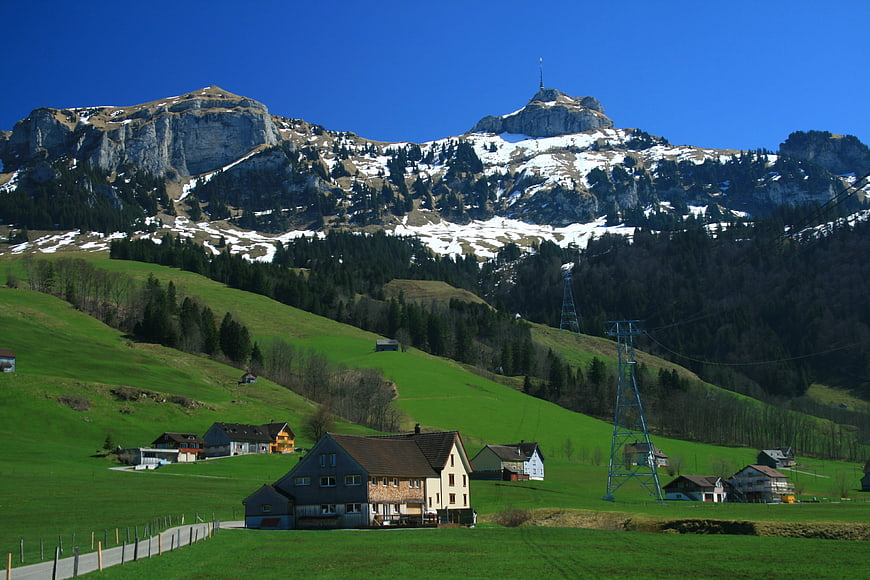 Swiss Alps landscape with green meadows and traditional chalets