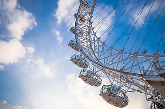 Low angle view of London Eye against blue sky