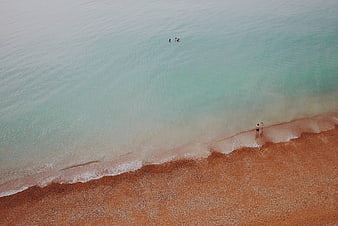 Aerial View of Turquoise Sea and Sandy Beach with People