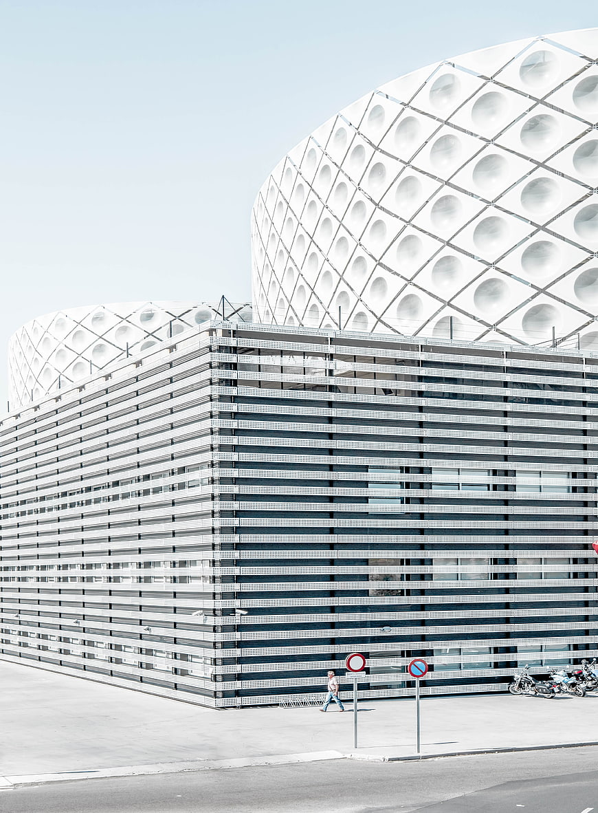 Modern white architecture with geometric patterns and parking garage
