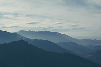 Misty Blue Mountain Ranges Under Cloudy Sky