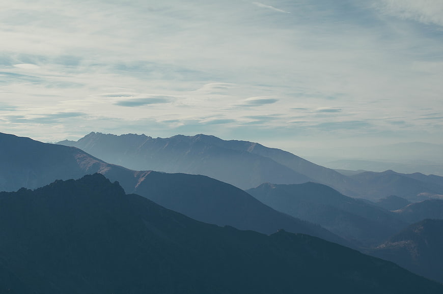 Misty Blue Mountain Ranges Under Cloudy Sky