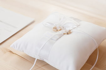 Gold Wedding Rings on White Pillow with Ribbon