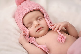 Sleeping newborn baby girl in pink knitted hat