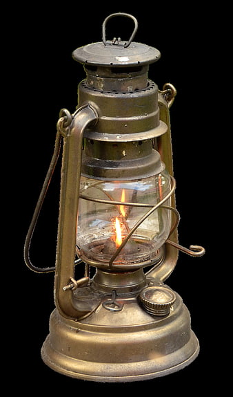 Antique brass kerosene lantern with lit flame on black background