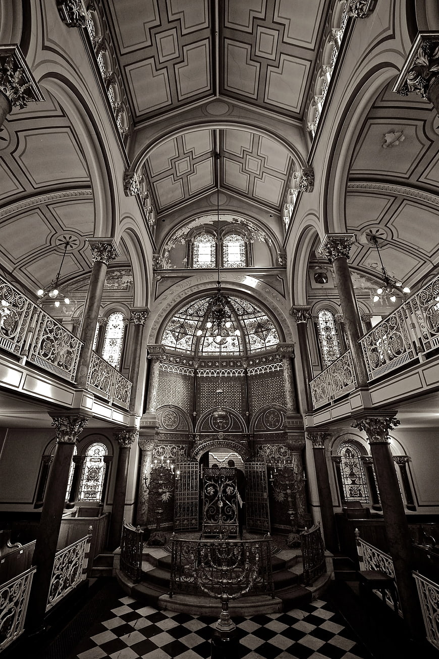 Black and white interior of ornate synagogue with checkered floor