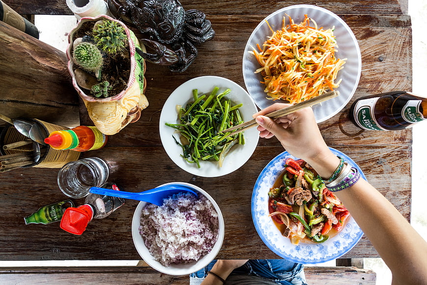 Top view of Vietnamese meal with rice, stir-fry, and papaya salad