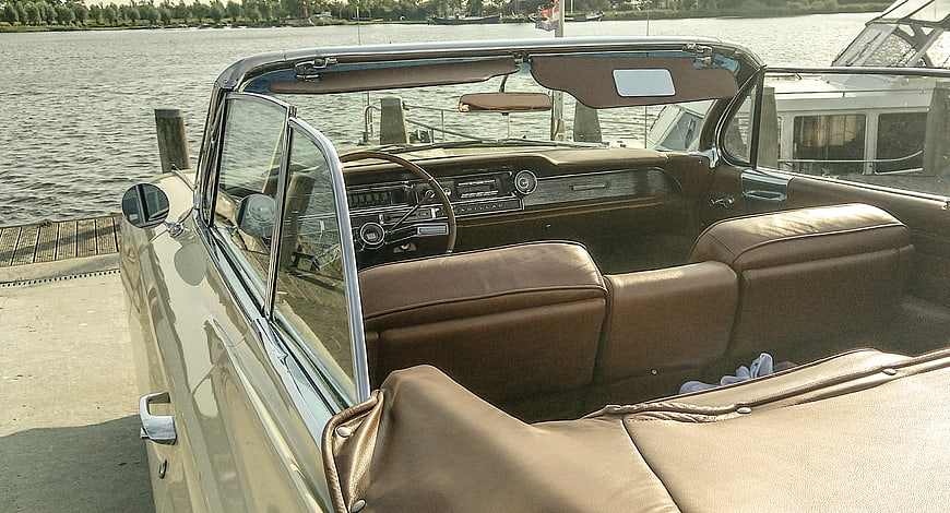 Vintage beige convertible car interior parked by the water