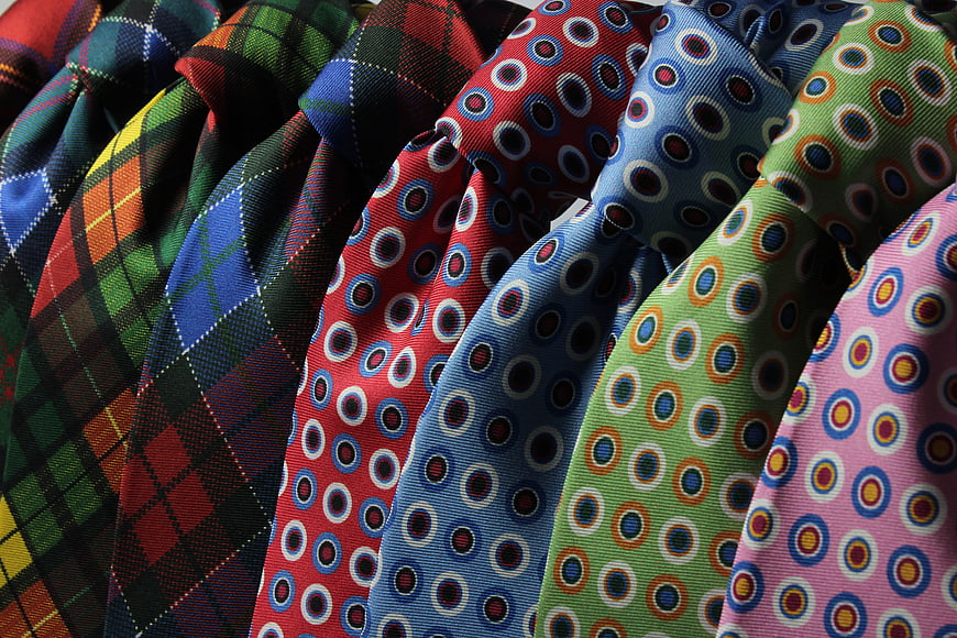 Colorful patterned neckties arranged in a row closeup