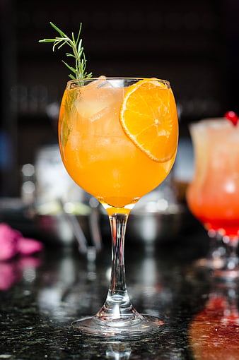 Refreshing Orange Cocktail with Rosemary Garnish on Bar