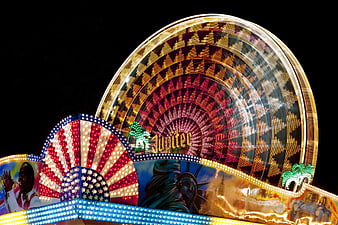 Illuminated Ferris Wheel At Night With American Flag And Statue Of Liberty