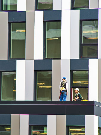 Construction workers on modern building facade