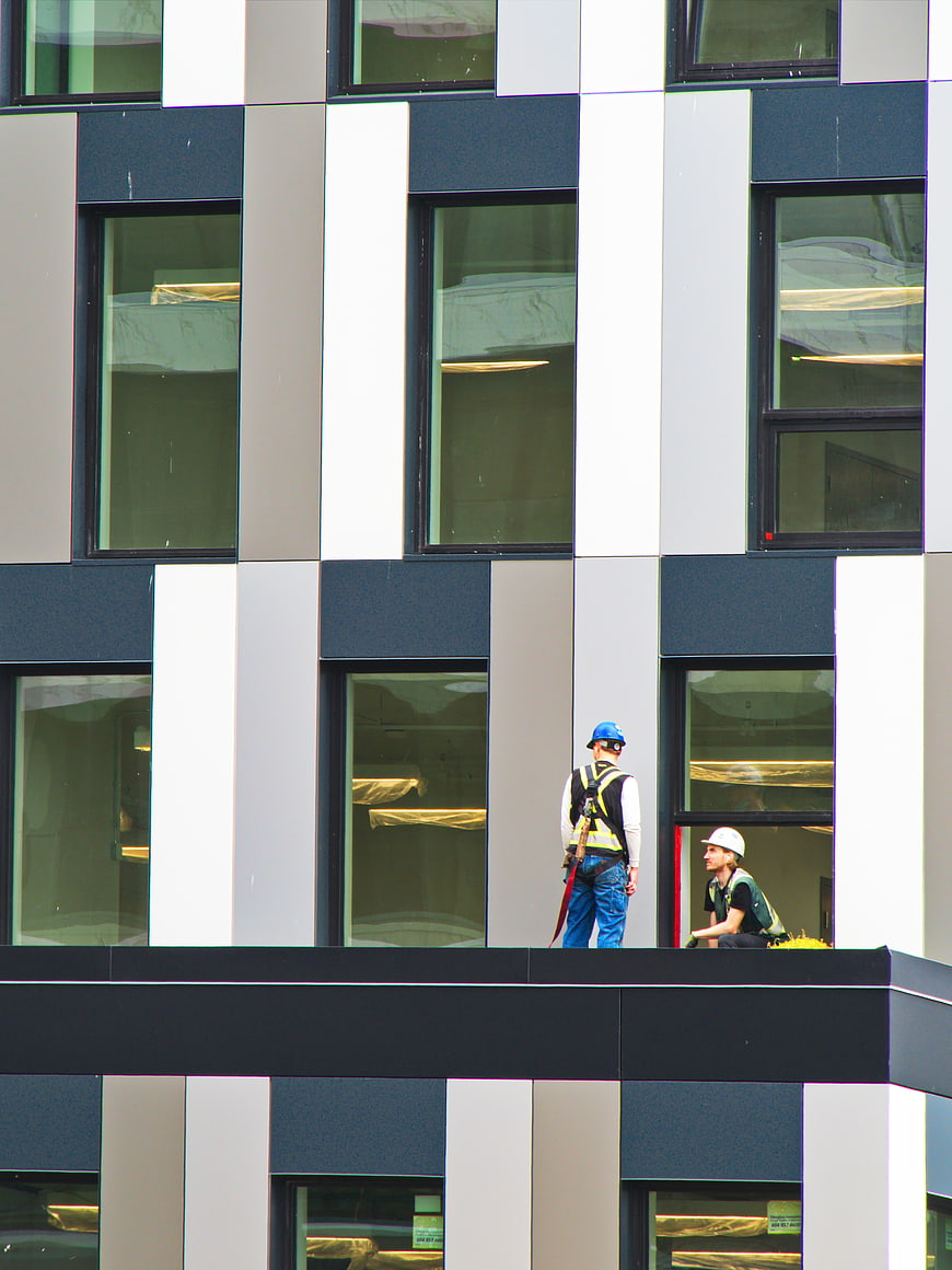 Construction workers on modern building facade