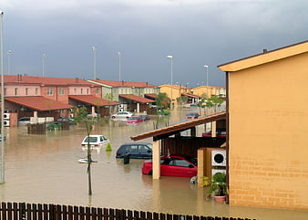 Flooded residential neighborhood with submerged cars and houses