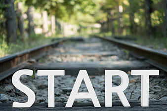 White Start Letters on Railway Tracks in Forest