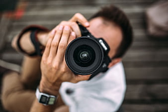 Close-up of Photographer Holding DSLR Camera Lens