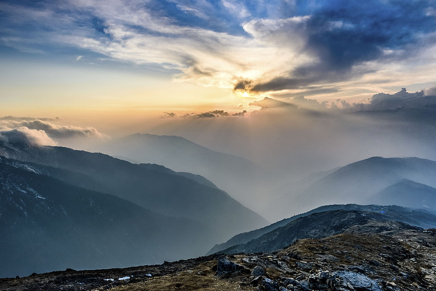 Dramatic mountain landscape with sun rays breaking through clouds