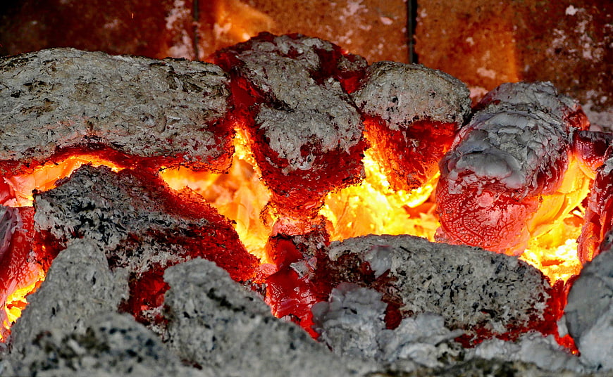 Glowing red hot coals and ash in a wood stove