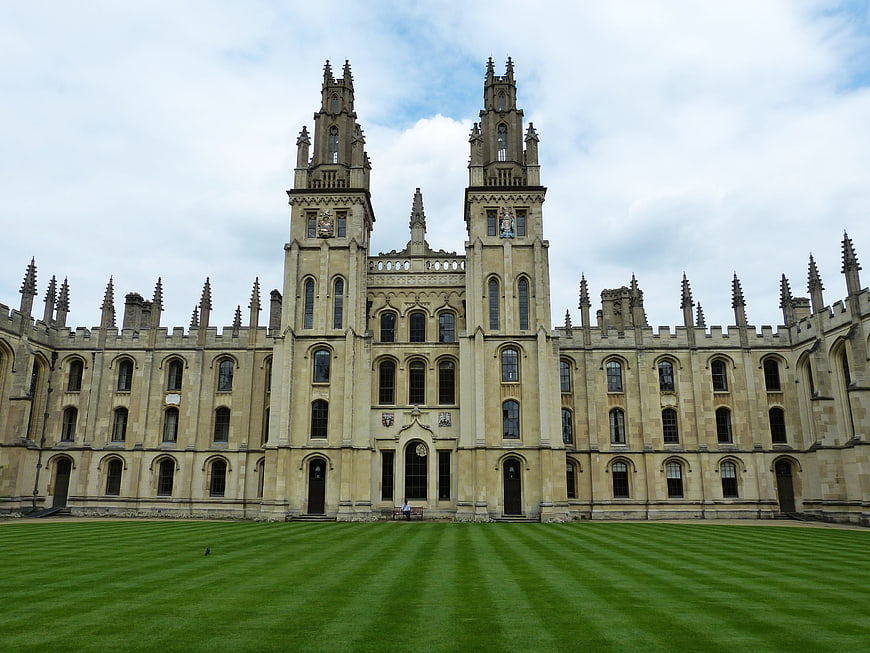 Historic Gothic University College Building With Twin Towers And Green Lawn