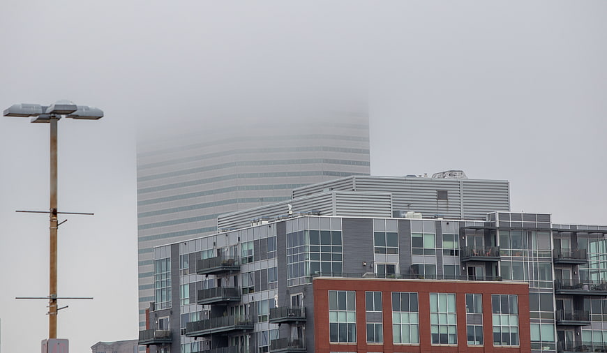 Foggy urban cityscape with modern buildings and street lamp