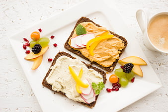 Healthy vegan breakfast with hummus toast and fresh fruit