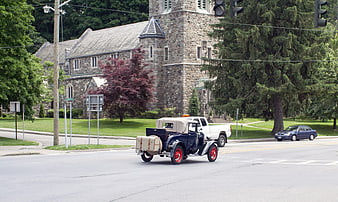 Vintage Ford Model A driving past stone church