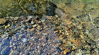 Clear rippling water over smooth river stones