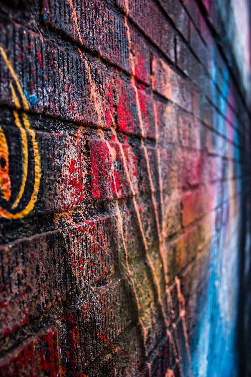 Close-up of colorful graffiti on a textured brick wall