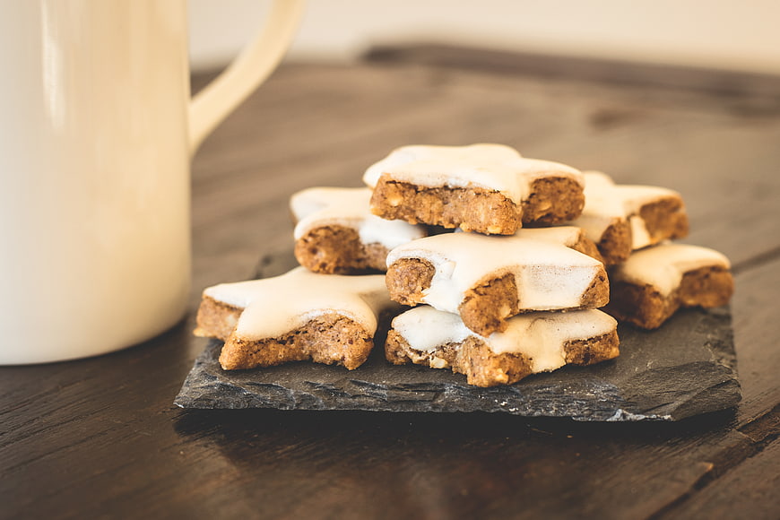 Star-shaped gingerbread cookies with white icing on slate