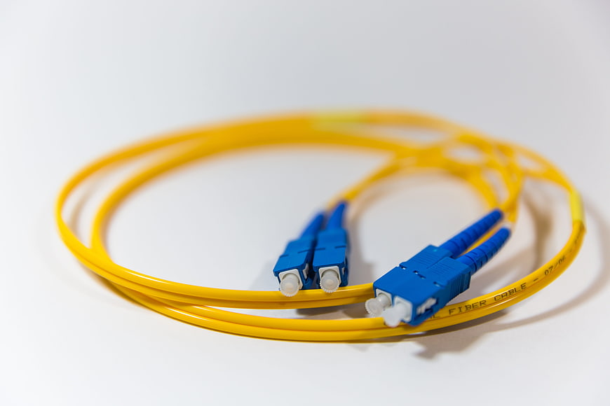 Yellow Fiber Optic Cable with Blue Connectors on White Background