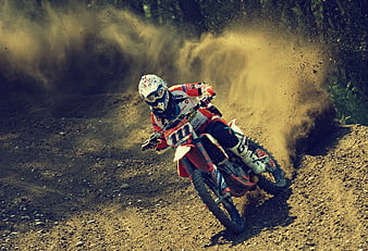 Motocross Rider Racing on Dirt Track with Dust Cloud