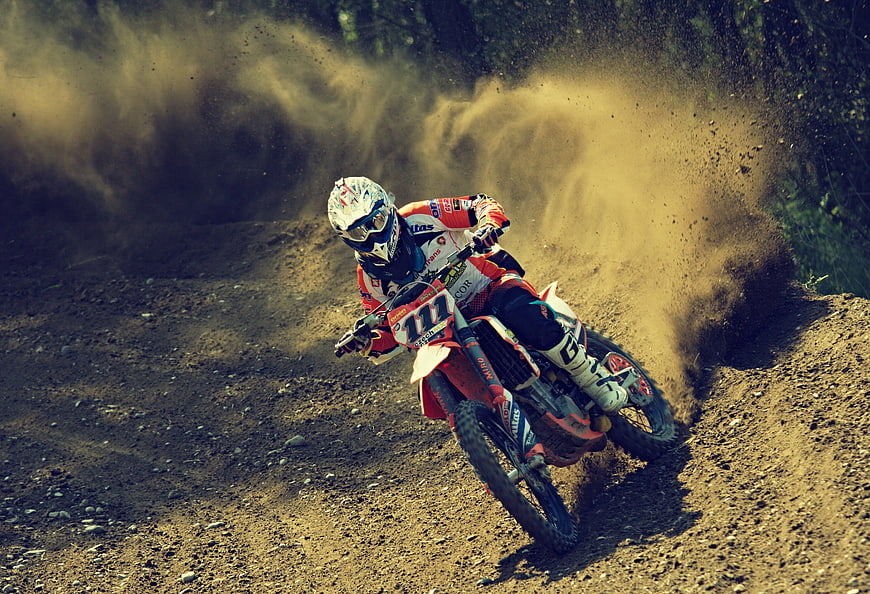 Motocross Rider Racing on Dirt Track with Dust Cloud