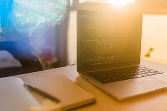 Laptop and Notebook on Desk with Sun Flare