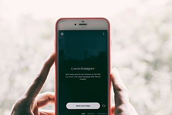 Hands holding smartphone with Instagram Live video interface