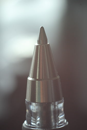 Macro close-up of a metallic ballpoint pen tip with blurred background