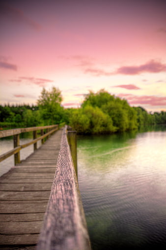 Wooden Bridge Over Lake at Sunset with Pink Sky