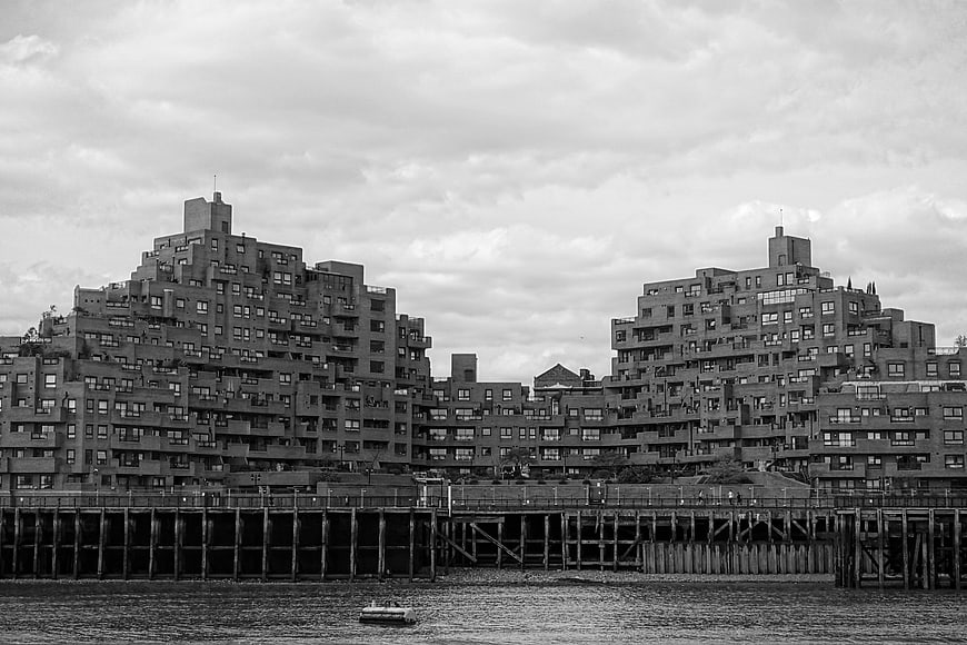 Black and white waterfront apartment buildings with pier
