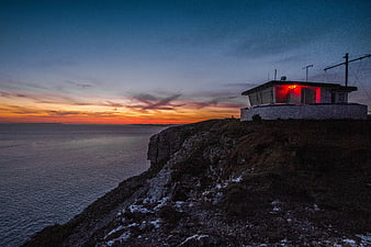Lighthouse on Cliff at Sunset with Red Light